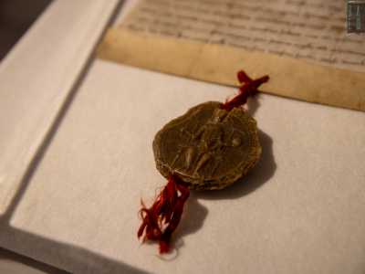 Al suddetto atto � legato con un nastro rosso lo stemma ufficiale reale in cera d�api, sul quale si vede l�imperatore che stringe fra le mani un globo e uno scettro: i simboli del sacro romano impero