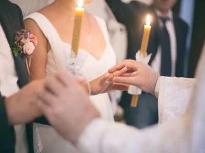 Il sacerdote scambia gli anelli agli sposi incrociandoli per tre volte mentre recita la formula di rito
