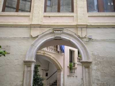 E al centro del prospetto si apre l'arco in pietra chiara che d� accesso alla corte del palazzo