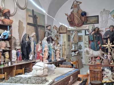 Le pareti e le mensole sono ricoperte di quadri, angeli, volti...