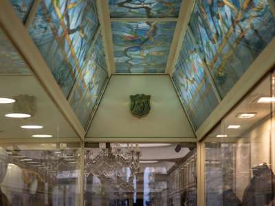 Percorriamo un lungo corridoio sotto un soffitto a mosaico azzurro e verde...