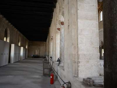 Attraverso una porta in legno si passa dall'esaforato al matroneo sinistro della Basilica: si notano un carrellino e una fila di armadietti bianchi posizionati sulla parete sinistra. Il matroneo era stato concepito per ospitare le donne durante le funzioni religiose