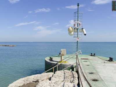 Alla fine del lungomare spicca un piccolo molo verde allestito in un rimessaggio di barche
