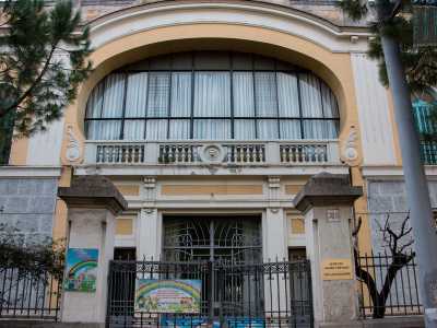 Ammiriamo la facciata superiore, bianca e gialla, che presenta una curiosa finestra circolare e il balcone con al centro una maschera apotropaica che raffigura un leone che protegge i bambini e le suore da presenze maligne