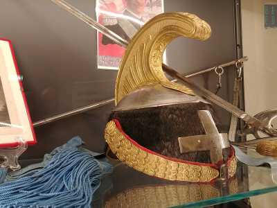 In una vetrina vicina spicca un cimiero impreziosito da fregi dorati e una vistosa croce in ferro, appartenuta un membro del glorioso reggimento "Savoia cavalleria"