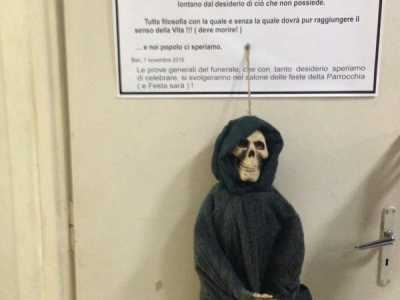 Dal manifesto pende un fantoccio che rappresenta la morte
