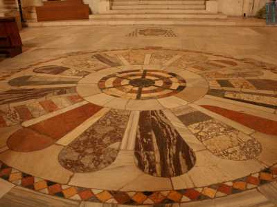E� arrivato il tempo di andare via, ma mentre la penombra della luce del tramonto ricopre lentamente la navata centrale, il nostro sguardo cade sul mosaico pavimentale al centro della chiesa