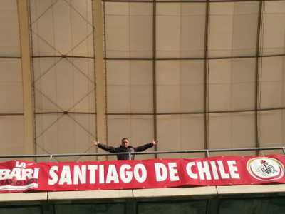Il 46enne Carlos Puelma in posa assieme allo striscione che indica la nascita del "Bari club Santiago del Cile", esposto per la prima volta il 22 novembre dello scorso anno nella tribuna est dello stadio San Nicola