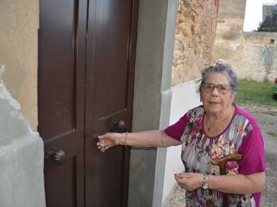 E finalmente vediamo apparire un'arzilla signora di 90 anni, dagli occhi vispi e scrutatori. Salutata affettuosamente da tutti, toglie la catena del viale e finalmente apre la chiesa