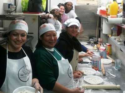 Alcune cuoche di Ethnic Cook ospiti nella cucina di un ristorante per la preparazione di una cena