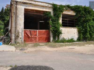 Siamo di fronte alla mitica Ferrero. Fra le tante saracinesche chiuse e ingressi sbarrati da assi di legno, solo uno � praticabile, sebbene bloccato da una rete rossa