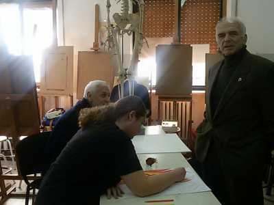 Due alunni lavorano alla cattedra per problemi di spazio, durante la lezione di Anatomia artistica