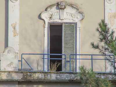 Una delle finestre dell'edificio: i vetri sono rotti e le persiane lesionate