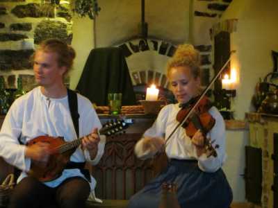 All'interno di una locanda dei musicisti intrattengono i clienti