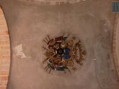 Il simbolo patrizio si ripropone sotto l'arco che incontriamo poco dopo aver varcato l'entrata principale. Si tratta di un affresco impreziosito da un lampadario: consiste essenzialmente in tre palme intrecciate attorno a un elmo su sfondo azzurro, dettagli che suggeriscono l'abitudine dei Palmieri a compiere pellegrinaggi