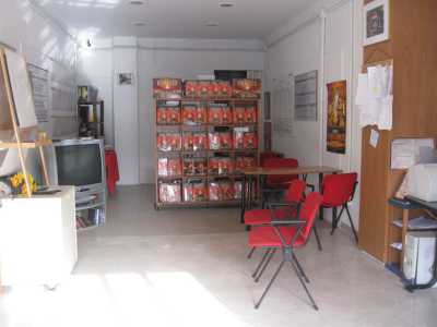 Una veduta del locale con le poltroncine rosse, la televisione e la libreria 