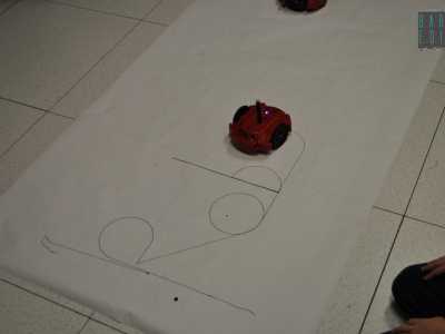Uno dei congegni comincia a comporre la scritta Robocup JR grazie al pennarello incorporato