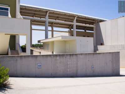 La prima struttura � collegata, tramite un ponte dalla tettoia trasparente, a un secondo capannone bianco e grigio
