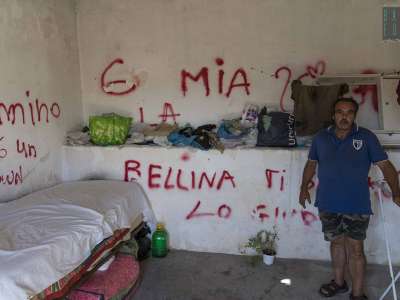 In una stanza sono accatastati tutti i suoi vestiti. C�� un letto e sparse qui e l� delle damigiane in plastica con pochissima acqua recuperata da una fontana pubblica che si trova nelle vicinanze. I muri sono tutti pieni di scritte, tra parolacce e dediche d�amore