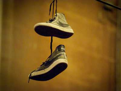Le scarpe appese in via Dante viste da vicino: si tratta di sneakers grigie
