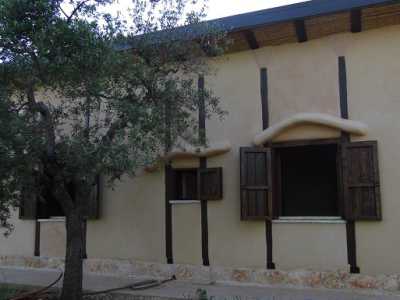 Retro della casa di paglia a Conversano: sulle finestre sono ben visibili le particolari pensiline fatte di rami d'ulivo intrecciati, riempiti di paglia e ricoperti da strati di terra cruda e calce  
