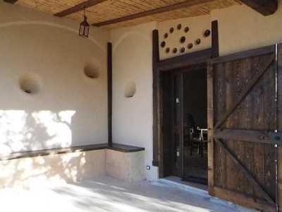 La veranda-ingresso della Casa di paglia: gli incavi nel muro ospitano lumi e candele