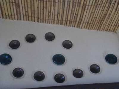 Particolare sull'ingresso della casa in paglia: la decorazione � ottenuta con fondi di bottiglia di colori differenti che creano giochi di colore e lasciano filtrare la luce