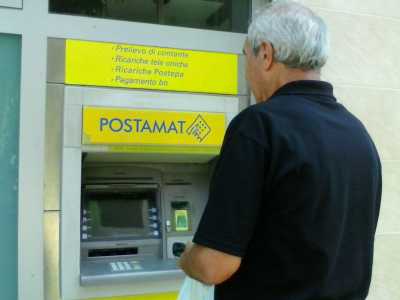 Il signor Pasquale Aiuola mentre aspetta che torni la corrente elettrica davanti al postamat dell'ufficio postale di Santo Spirito, per poter avere le banconote richieste e rimaste bloccate dalla sospensione di energia elettrica