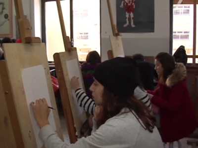 Alcuni studenti durante la lezione di anatomia artistica. I cavalletti da disegno sono troppo vicini l'uno all'altro e i ragazzi non hanno neanche lo spazio per  lavorare
