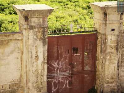 L�area � circondata da spesse mura alte circa quattro metri, interrotte solo da un arrugginito e imbrattato cancello in ferro rosso, su cui spiccano le sagome delle lettere che compongono la dicitura �Villa Rosa�, con le iniziali del nome del proprietario �G.M.�