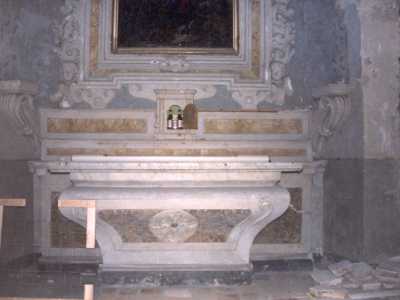 Dettaglio dell'altare maggiore, nella lunetta delle ostie si vedono alcune bottiglie e lattine vacanti di birra 