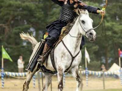 Un arciere a cavallo con in mano un arco mediorientale durante una sessione di caccia