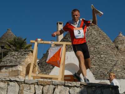 Un atleta di orienteering raggiunge un punto di controllo durante una corsa nel centro storico di Alberobello