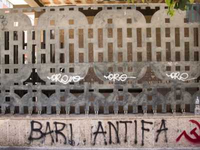 Un particolare della cancellata imbrattata da scritte di natura politica