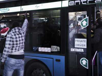 Gli affollatissimi pullman del Cara a una delle fermate prestabilite 