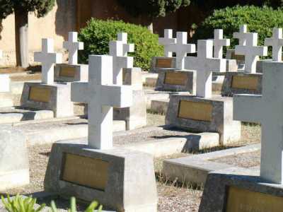Ai nostri lati osserviamo in silenzio decine e decine di croci bianche disposte per file: ciascuna di esse ha una targa in bronzo che indica grado militare, nome, cognome, data di nascita e di morte del caduto