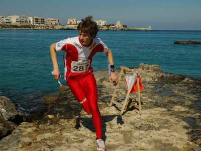 Un giovane atleta, dopo aver marcato il cartellino nei pressi della lanterna,  riparte velocemente per raggiungerne un'altra. La gara si svolge sulla costa