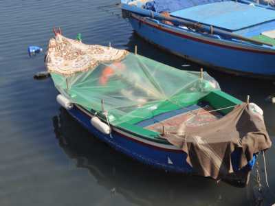 Un gozzo attraccato a Nderr a la lanz protetto da un telo di plastica