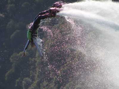 Lo sportivo, dopo avere eseguito l'acrobazia, si tuffa in acqua 