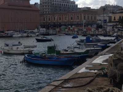 Gozzi cullati dalle acque nei pressi del molo Sant'Antonio. A sinistra si intravede il Teatro Margherita