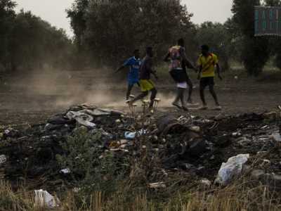 Partita di calcio organizzata tra polvere e rifiuti dai profughi del Ghetto dopo una giornata di lavoro