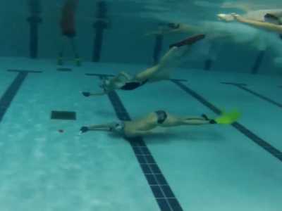 il primo ad arrivare al centro della piscina non perde tempo e passa con la mazzetta il disco al suo compagno