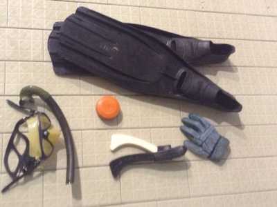 Gli attrezzi utilizzati per giocare ad hockey subacqueo: mascherina e boccaglio, pinne, dischetto di piombo rivestito in plastica, mazzetta di legno e guanto protettivo 