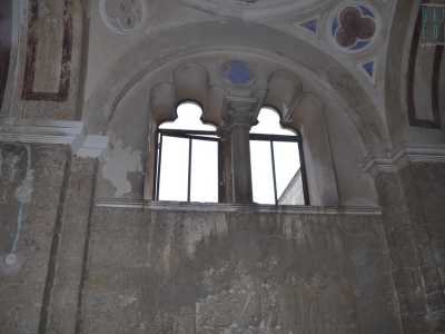 La particolare e orientaleggiante bifora in alto dona luce al locale affacciandosi sul cortile interno