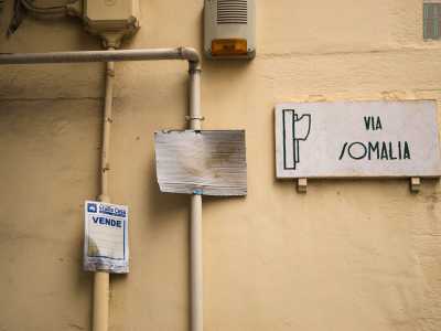Ci infiliamo sulla destra nella piccola via Somalia, con la sua targa littoria che ostenta il simbolo del fascio