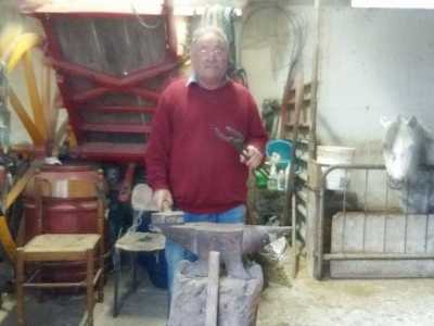 Il maniscalco Nicola nella sua piccola bottega a Palese, in via Modugno. Alle sua spalle un pony bianco