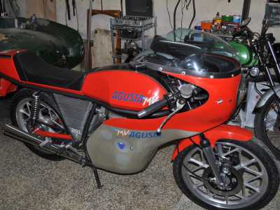 L�uomo ci guida all�interno del suo covo. Ammiriamo un�Agusta MV 350 del 76 rosso che Giovanni considera il suo �gioiellino�