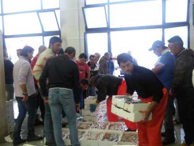 ... e si stringono intorno alla mercanzia non appena l'asta ha inizio