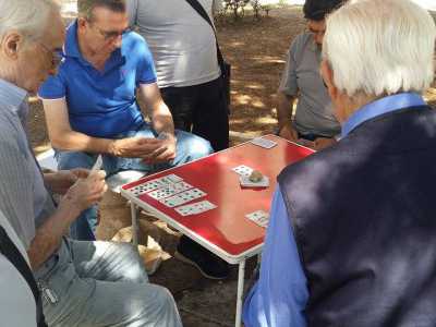 Pensionati che giocano su un tavolino pieghevole a Poggiofranco, mella piazzetta dei Papi