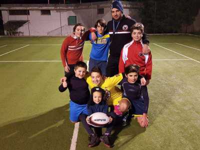 Alcuni giovani atleti di minirugby in posa prima di un allenamento nel campo sportivo di Turi